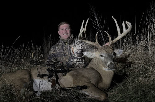 A table with a laptop facing a window.